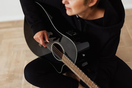 Free Person in Black Long Sleeve Shirt Playing Acoustic Guitar Stock Photo