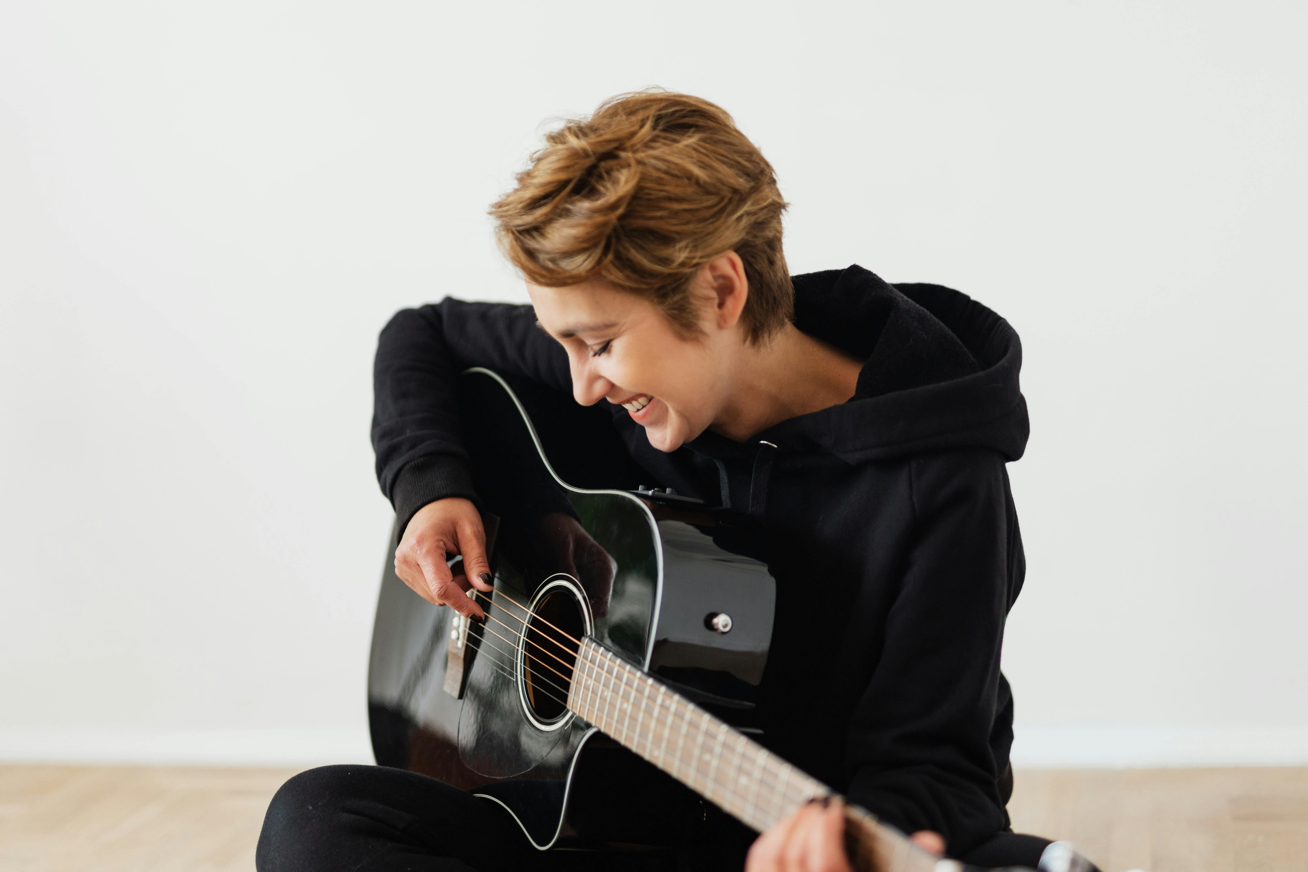 Person in Black Hoodie Playing Guitar · Free Stock Photo