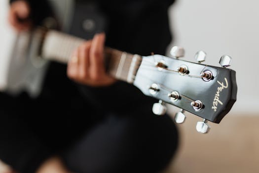 Detailed view of a Fender acoustic guitar headstock with tuning pegs in focus.