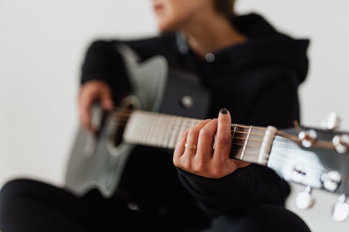 Free Close-Up Photo of Person's Hand Holding Acoustic Guitar Stock Photo