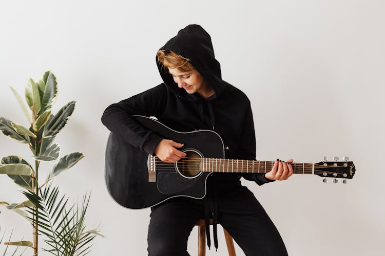 Cheerful Female Guitarist Improving Chord Playing Technique