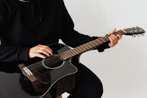 Photo of Person Holding Black Acoustic Guitar