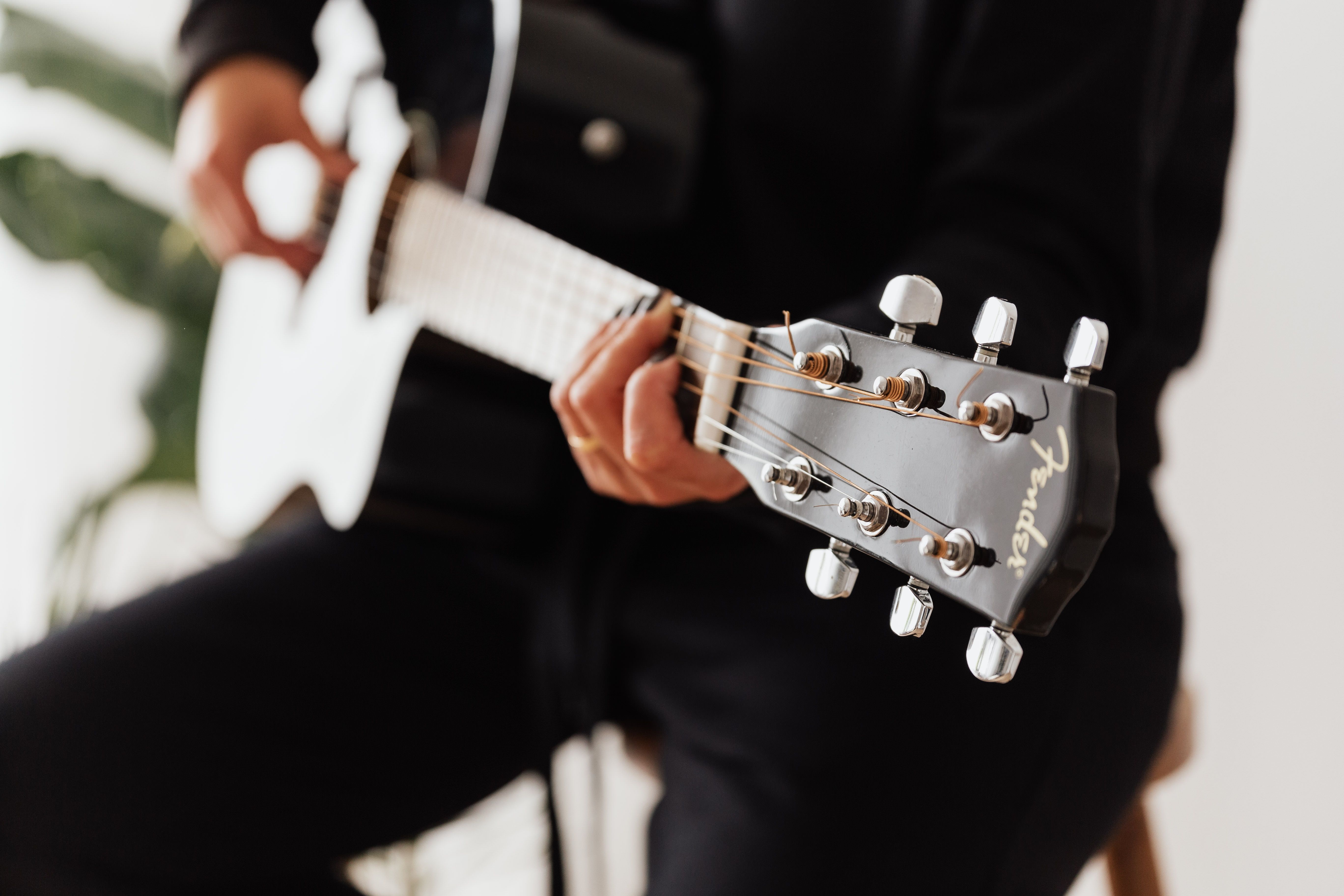 Crop unrecognizable female musician playing classic guitar in flat