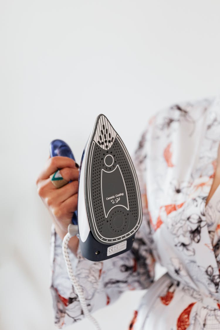 A Person Holding A Clothes Iron