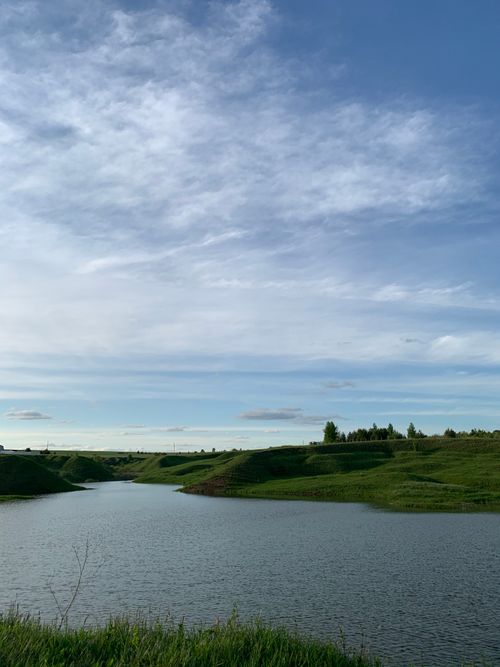 Free Rippling water surface of river flowing along green grassy shore in nature in daylight Stock Photo