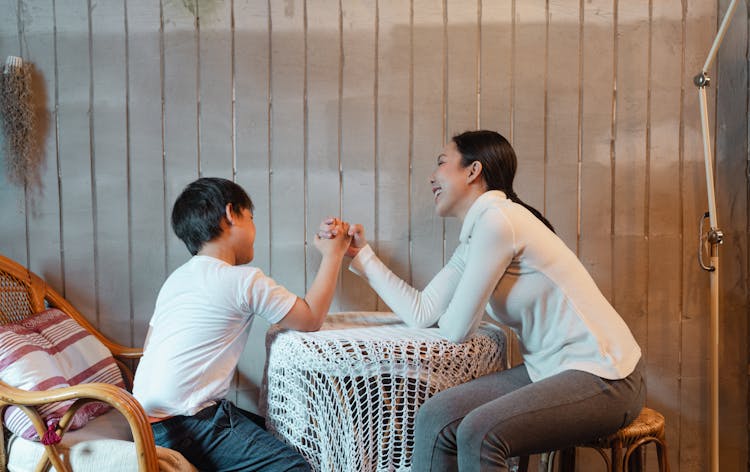 Cheerful Mother And Son Competing In Arm Wrestling