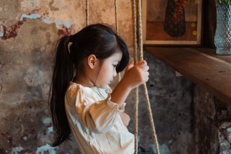 Calm Little Girl Riding On Swing