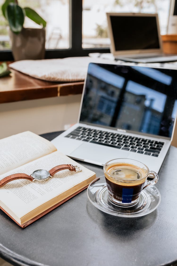 Shallow Focus Photo Of A Black Coffee Near A Book And Laptop