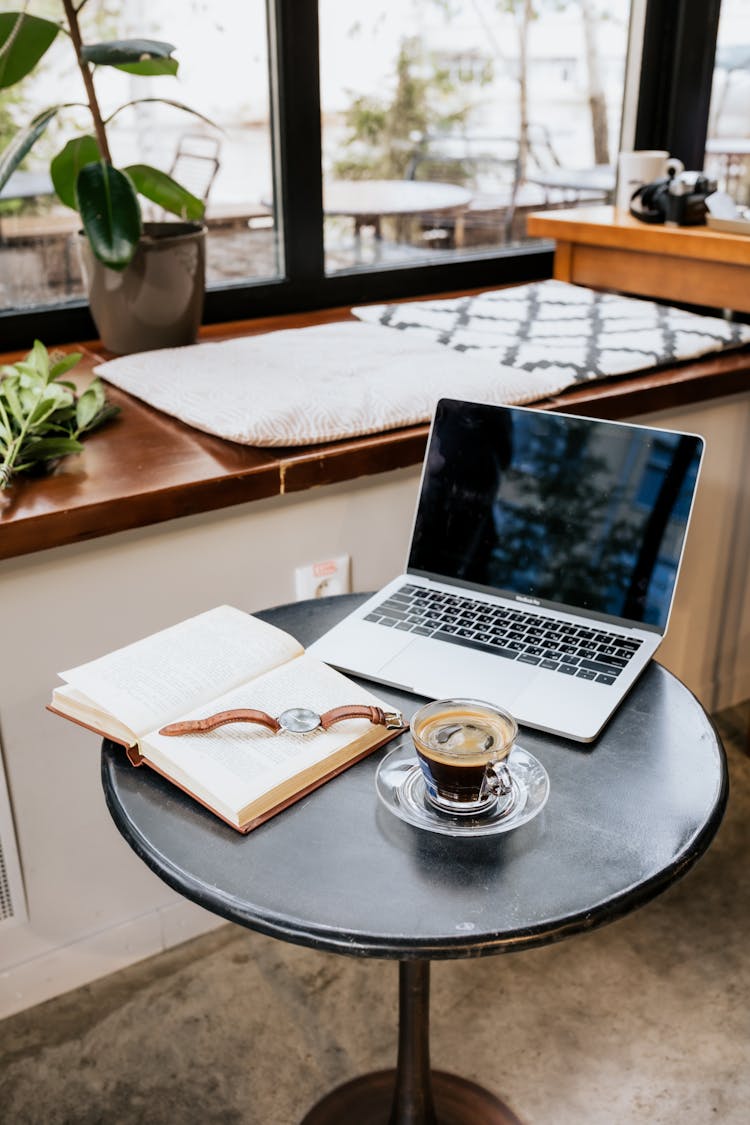 A Black Coffee Near A Book And Laptop