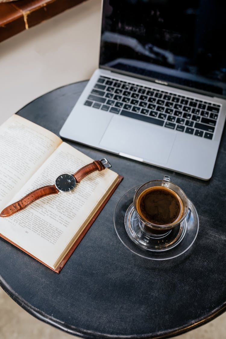 A Black Coffee Near A Book And Laptop