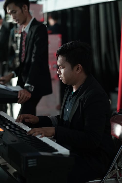 Man in Black Coat Playing Piano