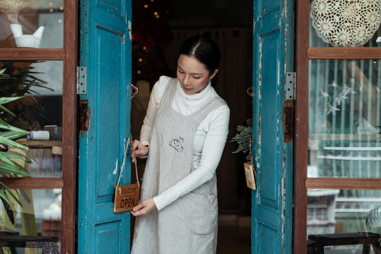 Content Woman Hanging Open Sing On Door