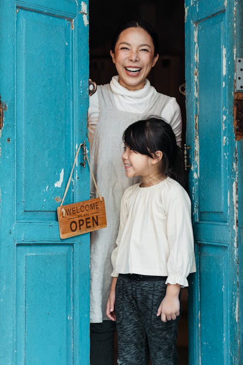 Photo of Woman and Girl Standing on Doorway
