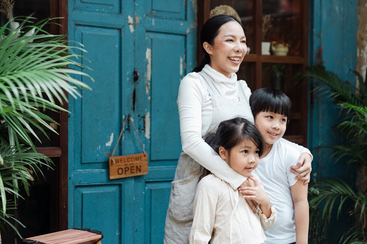 Photo Of Woman Smiling While Hugging Her Children