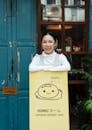 Woman Smiling While Leaning on Signage
