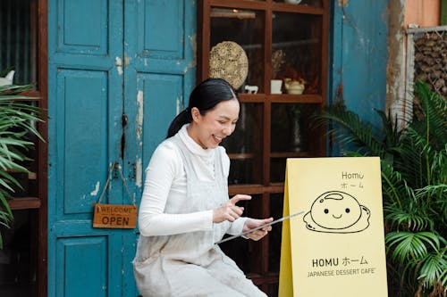 Photo of Woman Smiling While Using Tablet Computer