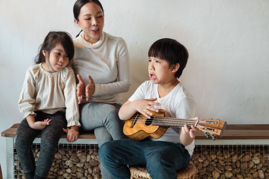 母亲和孩子们在室内一起演奏音乐，这是一个欢乐的家庭场景
