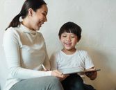 一位快乐的母亲和孩子在室内用平板电脑共度美好时光