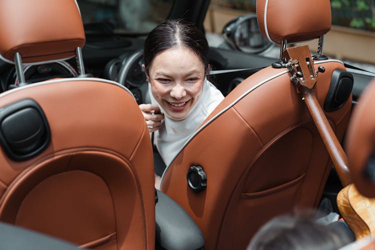 Happy Adult Asian Mother In Car Together With Crop Child