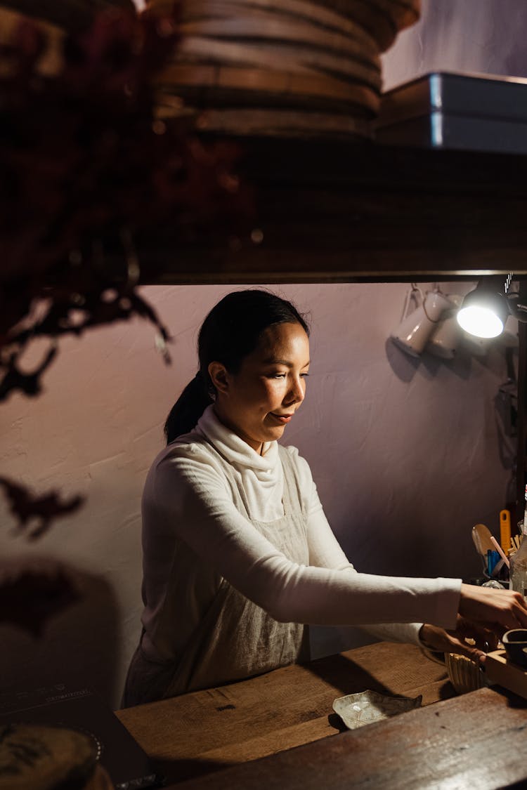 Confident Asian Woman Working In Cozy Cafeteria In Evening