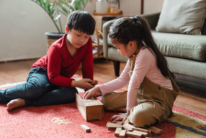 Young kids playing on a clean soft carpet in a bright living room