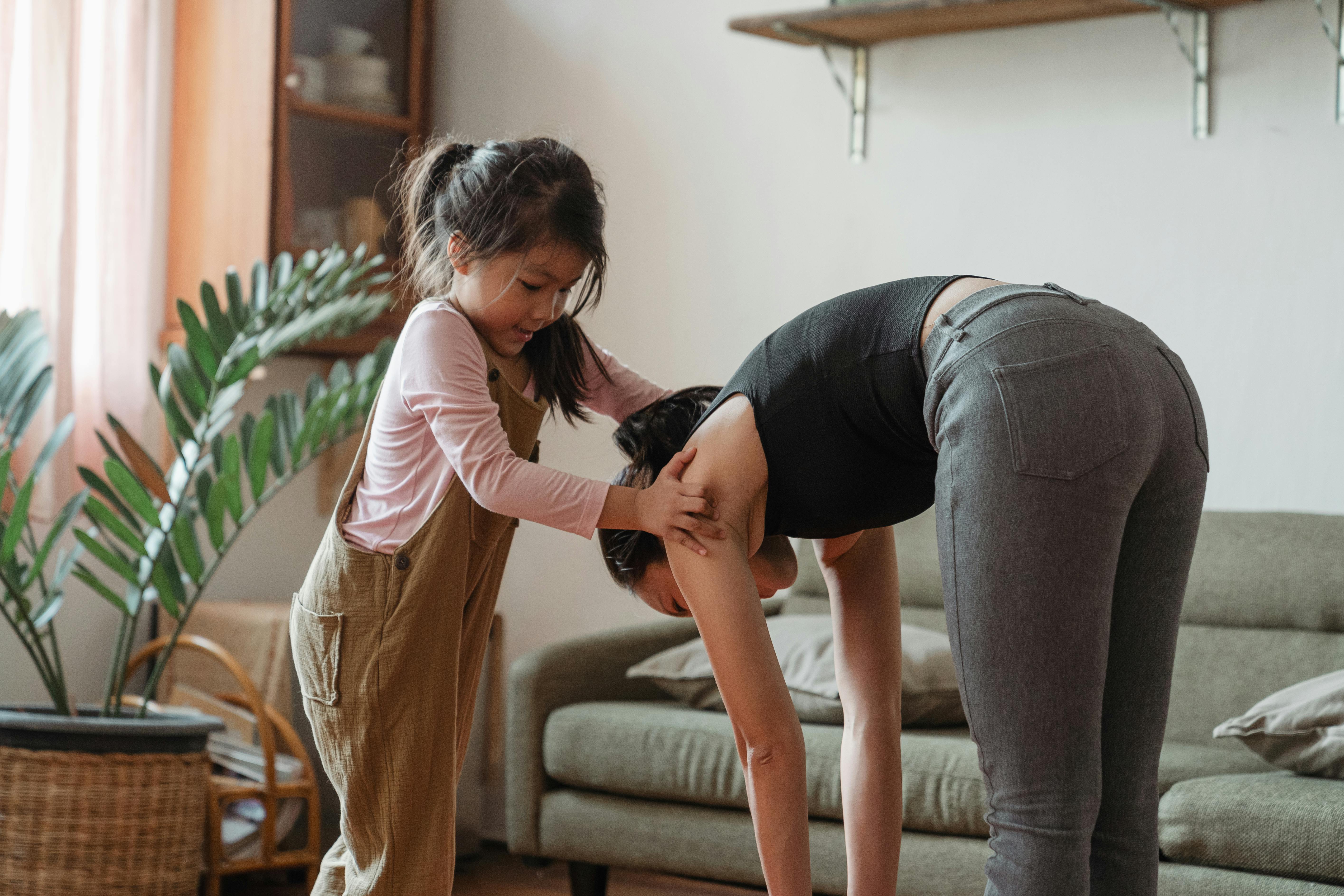 young flexible ethnic woman with cute daughter during workout together