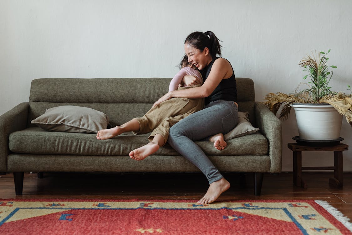 Free Photo of Woman Sitting on Couch While Hugging Her Child Stock Photo