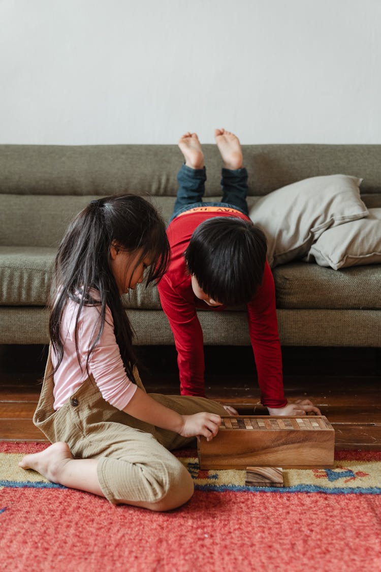 Adorable Barefoot Ethnic Brother And Sister Playing Tower Game At Home