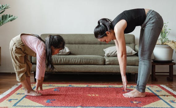 Side view of flexible young ethnic mother exercising with cute daughter while standing against each other on floor carpet near cozy sofa in modern living room in morning