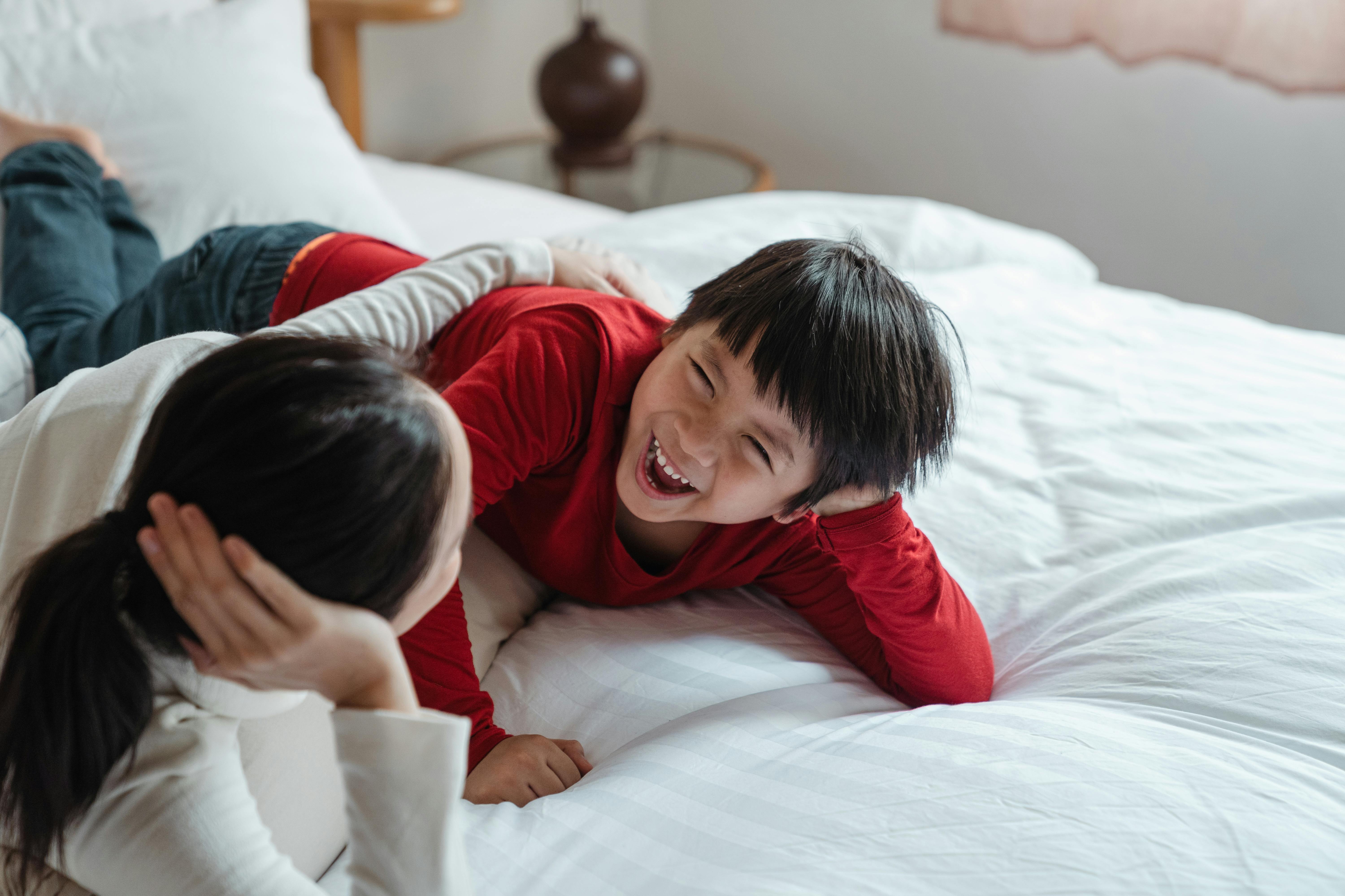 Mother and son lying down on the bed. | Photo: Pexels