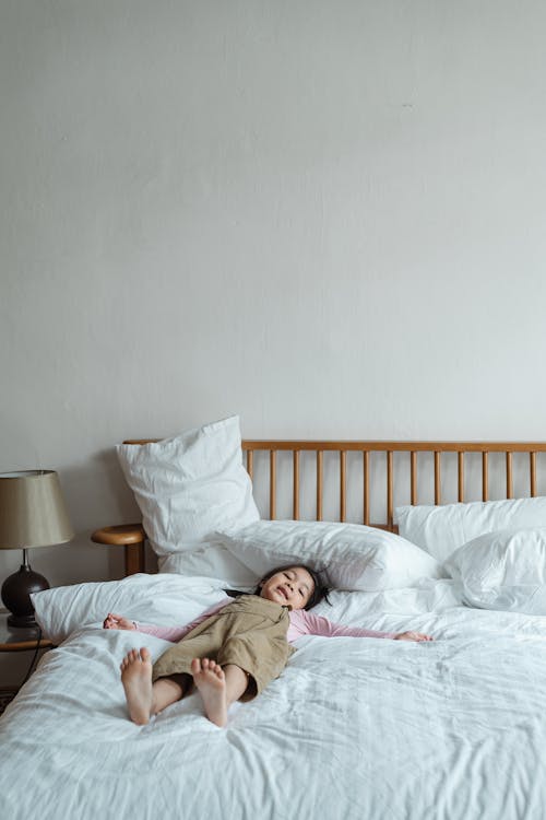 Free Girl Lying Down on Bed Stock Photo