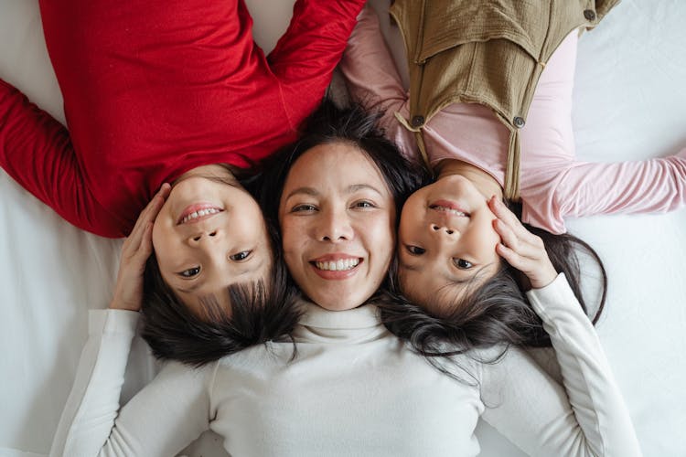 Happy Mother With Kids On Bed