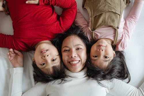 무료 여자와 그녀의 아이들이 침대에 누워있는 사진 스톡 사진