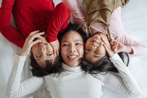 Foto De Uma Mulher E Seus Filhos Deitados Na Cama