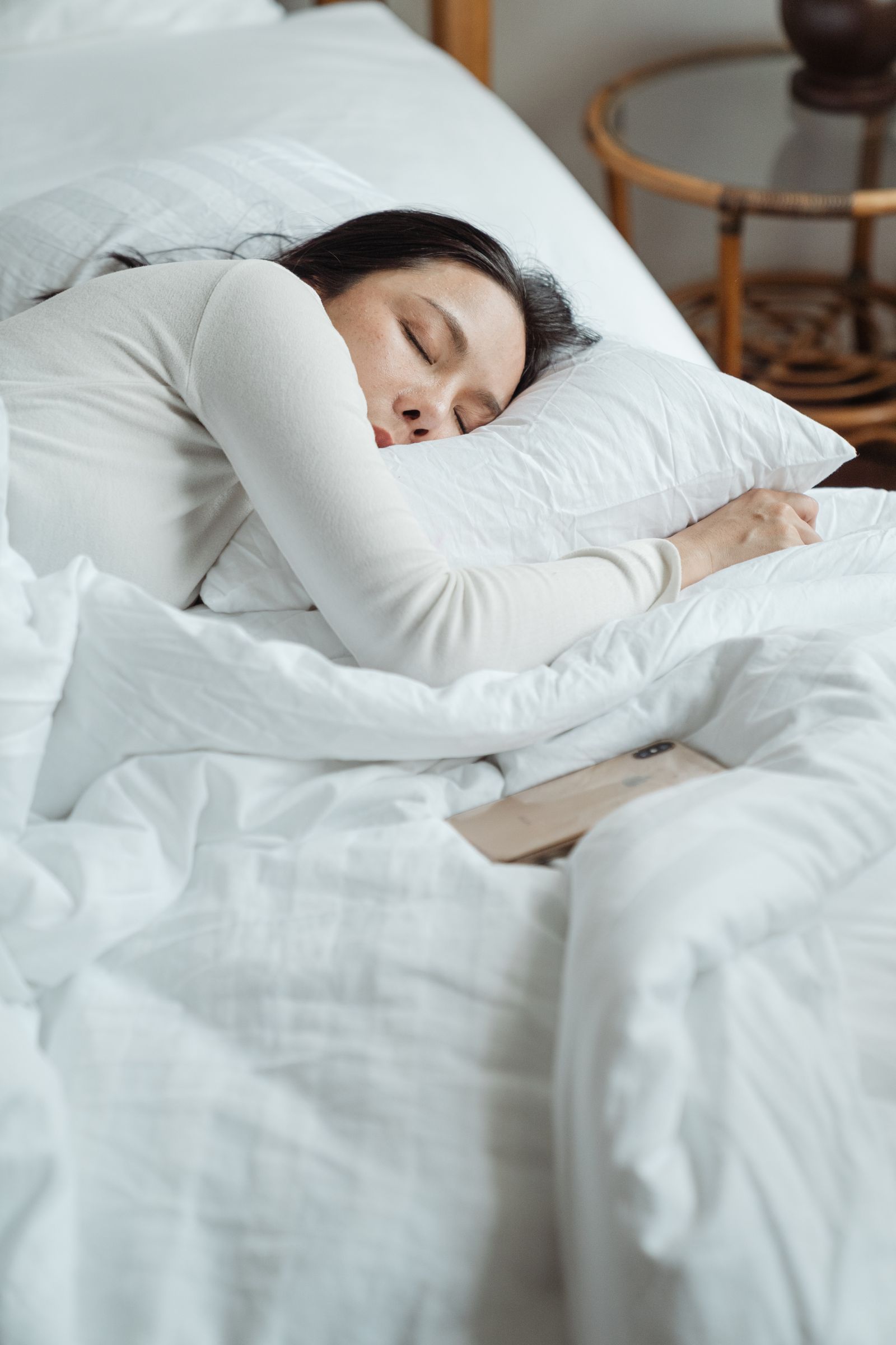 Woman sleeping in a bed with white bedding