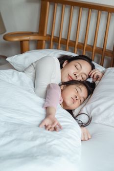这是一个宁静的时刻，母女依偎在床上，享受着安然的睡眠