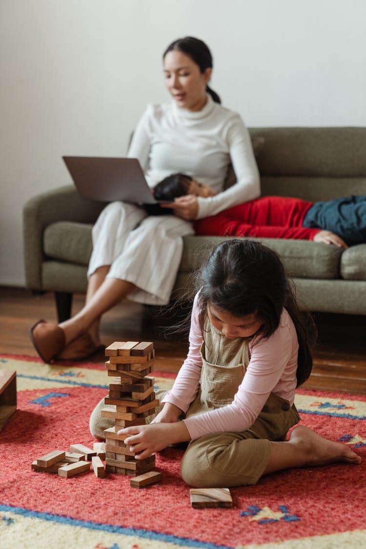 Mother Working On Laptop Near Cute Kids