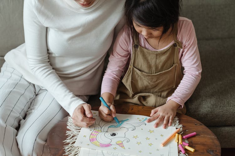 Crop Little Girl With Mother Coloring Picture Of Unicorn