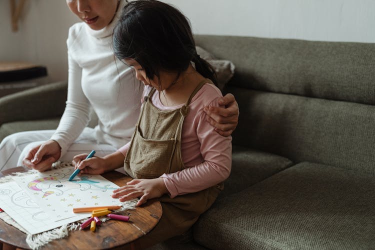 Focused Ethnic Girl Coloring Drawing Together With Mother