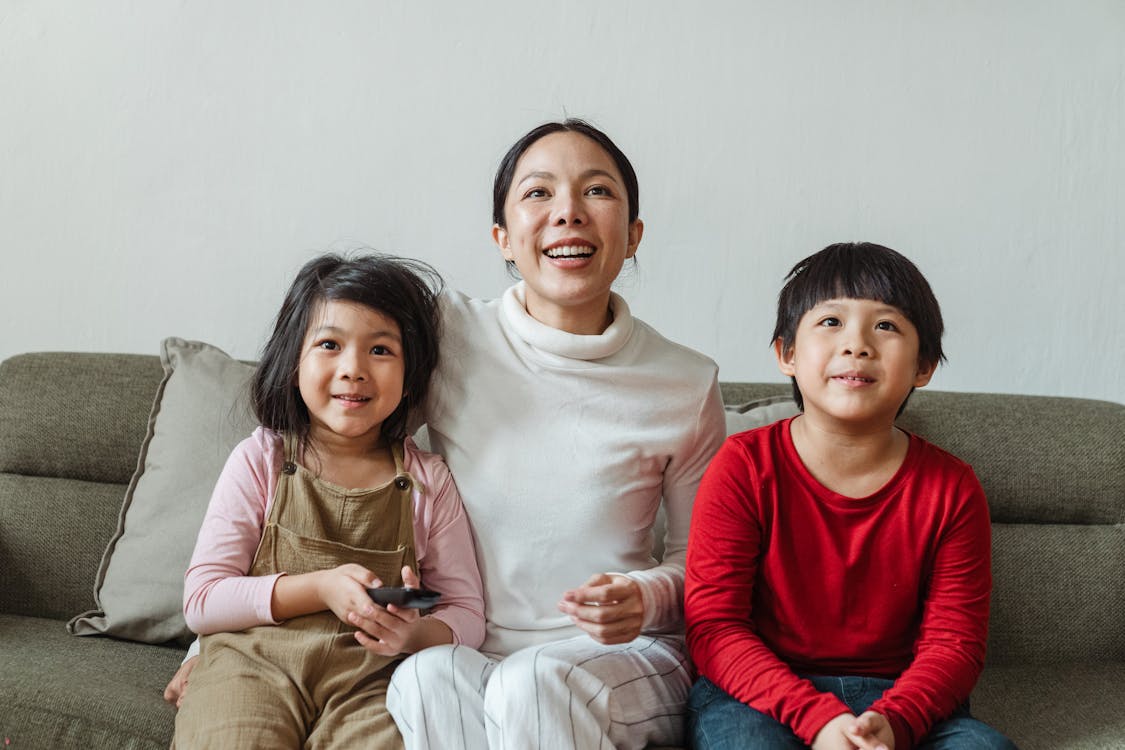 Interested Asian children with mother watching movie on TV channel · Free  Stock Photo
