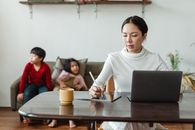 亚洲母亲在远程工作的同时，还要在家监督孩子