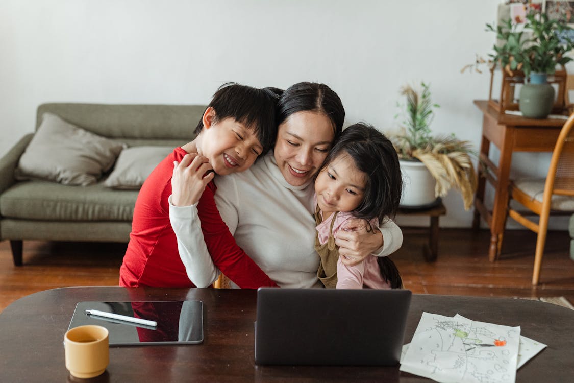 Happy mother and children hugging at home