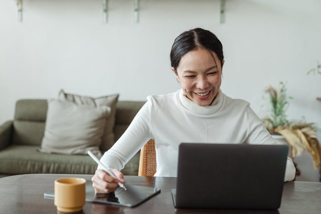 Woman working at home and making video call on laptop