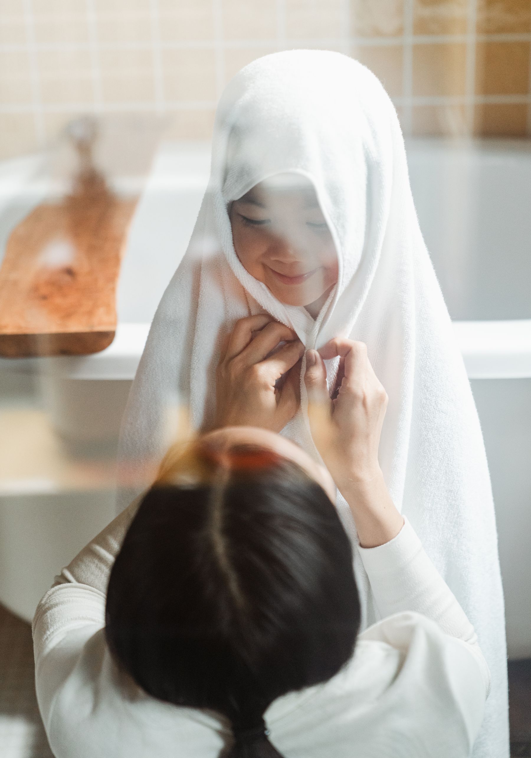 Mother gently drying a child with a towel after bath time