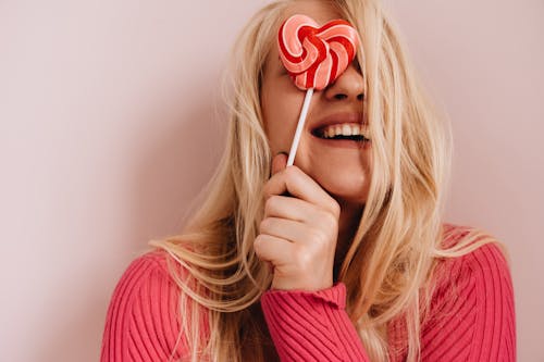 Free Photo of Woman Holding Red Heart Shaped Lollipop Stock Photo