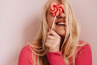 Photo of Woman Holding Red Heart Shaped Lollipop