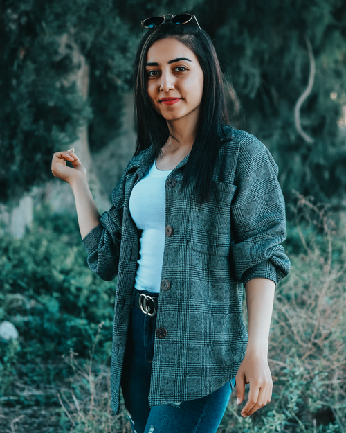 Free Content ethnic female in casual clothes standing on lawn in garden and tenderly looking at camera Stock Photo
