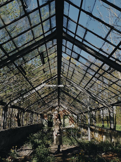 Woman in Run Down Abandoned Greenhouse
