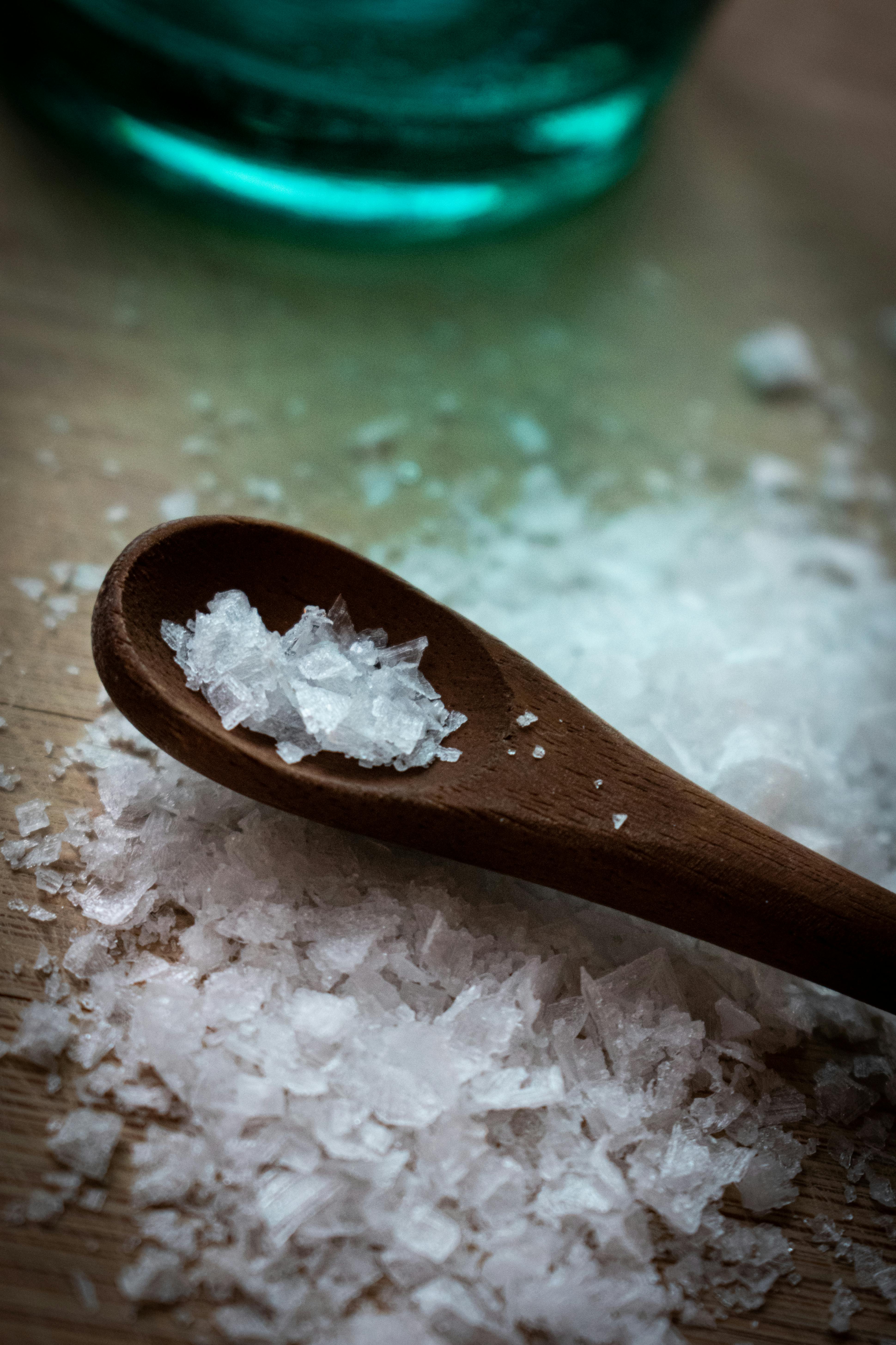 Free Detailed view of coarse sea salt crystals on a wooden spoon, perfect for culinary themes. Stock Photo