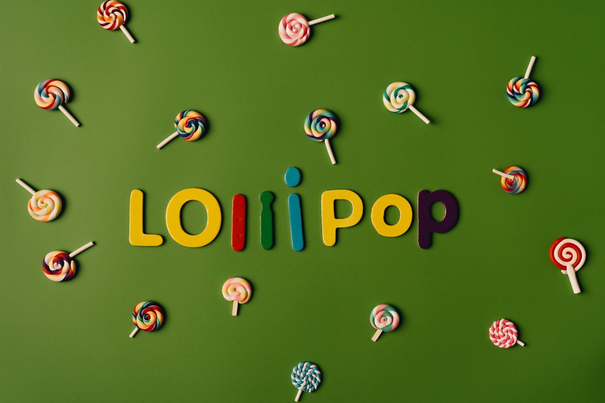 Vibrant lollipop arrangement spelling 'Lollipop' on a green background. Perfect for candy-themed projects.